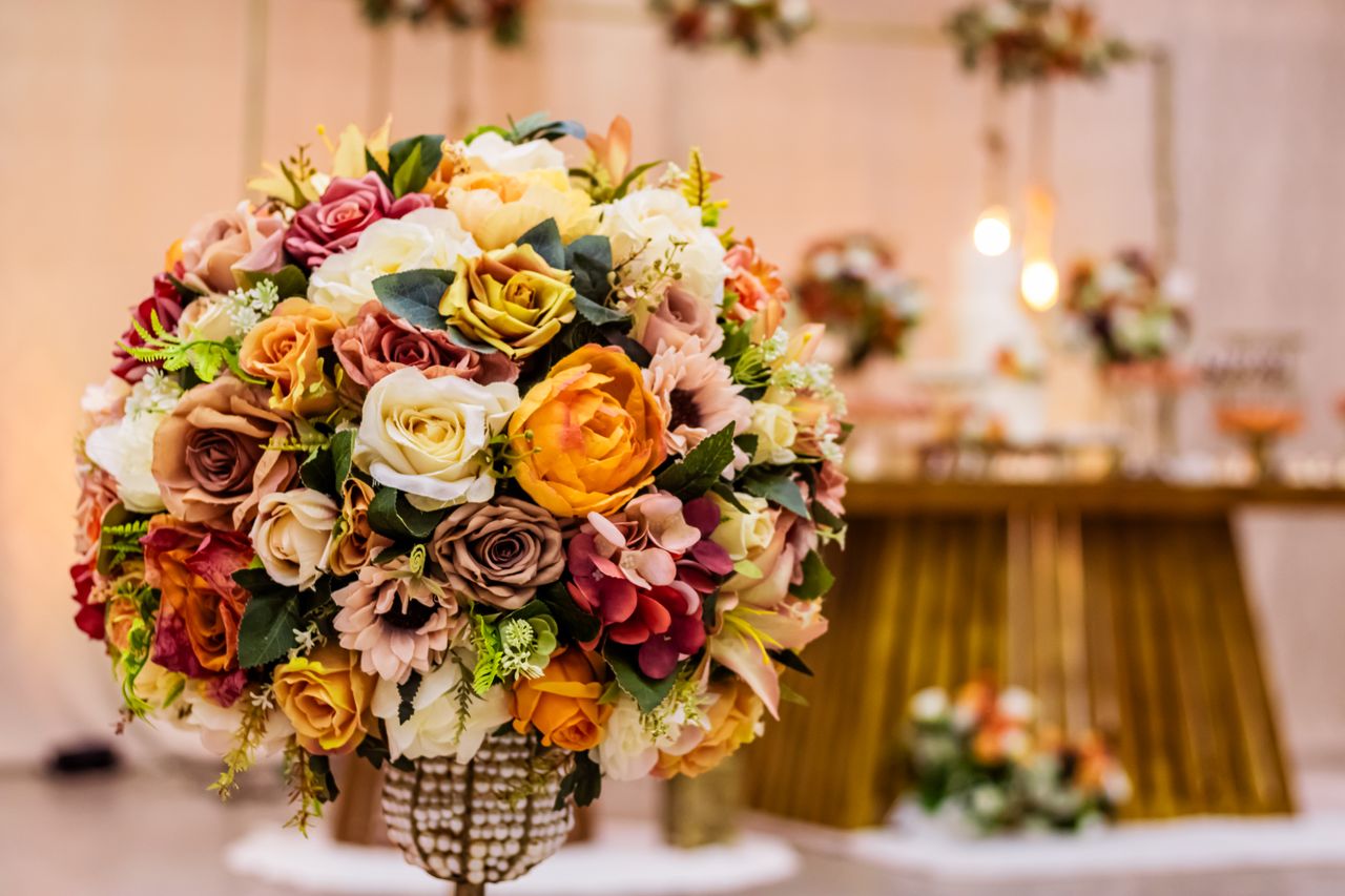 A vibrant floral bouquet centerpiece highlighting a wedding or event with warm, elegant colors.