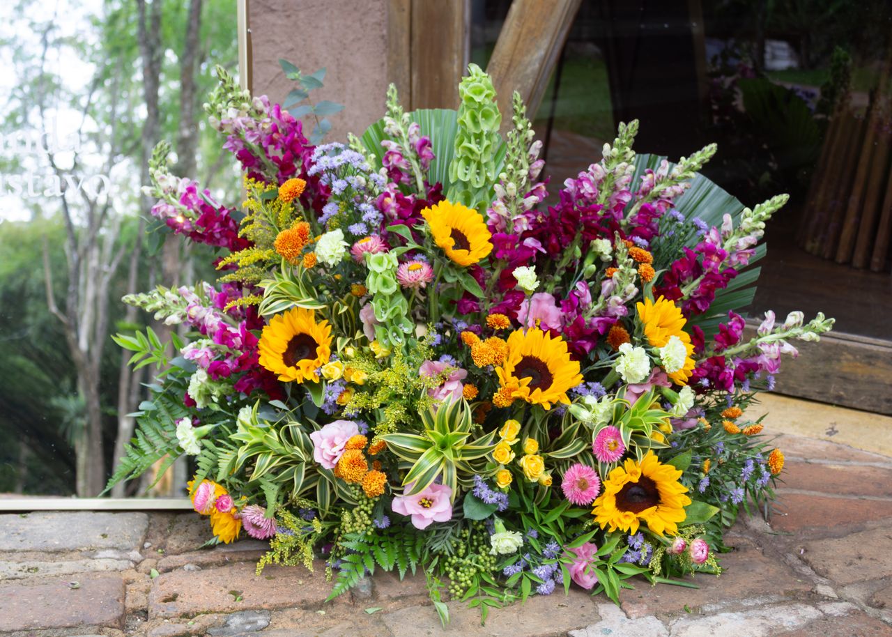 about-us Colorful floral arrangement featuring sunflowers and diverse blooms displayed outdoors in São Paulo.